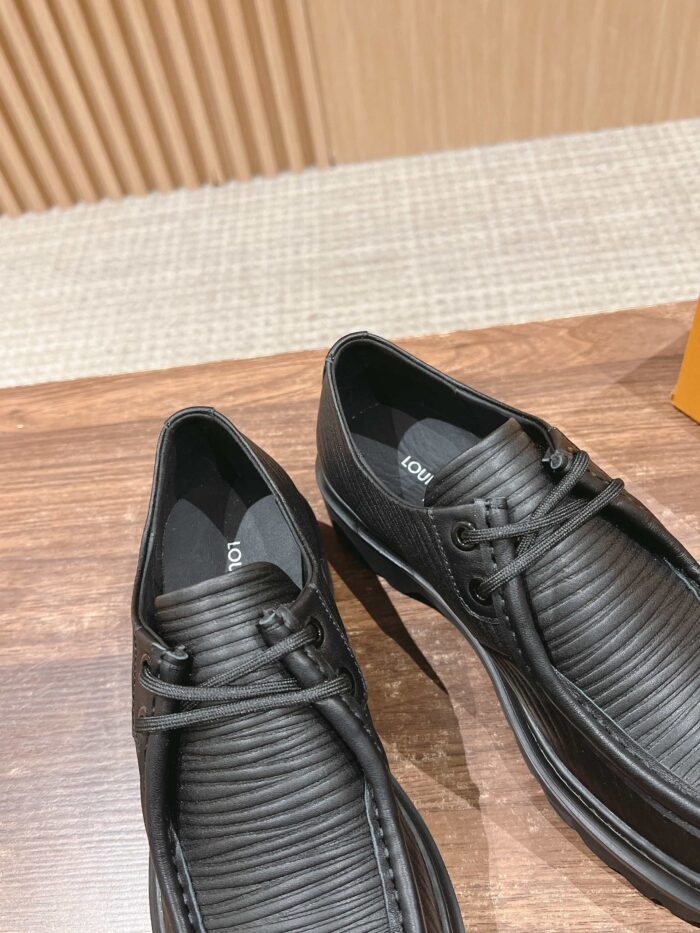 Scarpe nere moderne con texture a righe, su superficie in legno lucido, stile elegante e versatile.
