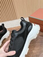 Scarpa nera moderna con suola spessa, dettagli eleganti e design trendy su superficie di legno.