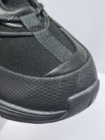 Sneaker nera moderna con materiali traspiranti, punta rinforzata e design sportivo elegante.