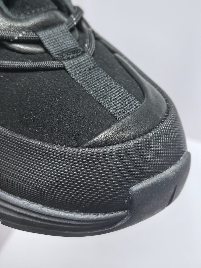 Sneaker nera moderna con materiali traspiranti, punta rinforzata e design sportivo elegante.