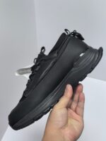 Sneaker nera moderna, leggera, confortevole, con suola antiscivolo e dettagli riflettenti.