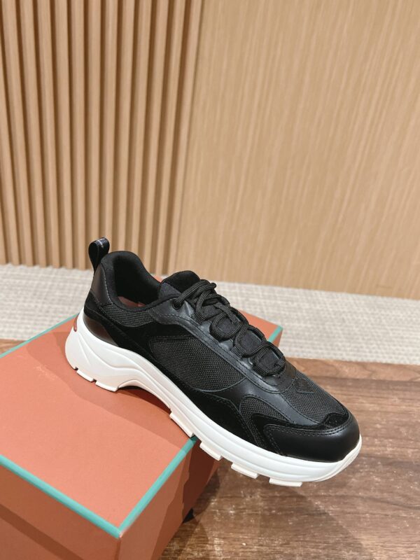 Sneaker nero moderna con suola bianca, design elegante, su scatola colorata e sfondo in legno caldo.