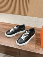 Sneaker nere moderne con suola bianca su superficie in legno, stile casual e di tendenza.