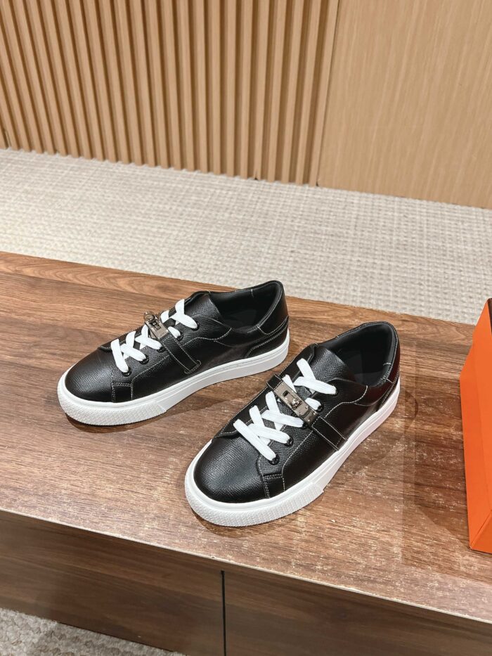 Sneaker nere moderne con suola bianca su superficie in legno, stile casual e di tendenza.