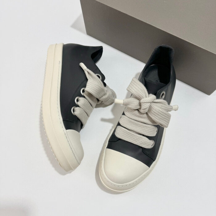 Sneakers nere moderne con lacci a nastro, suola bianca e design urbano elegante.