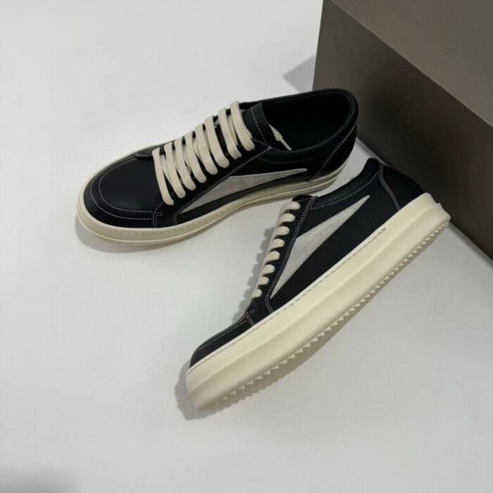 Sneakers nere moderne con dettagli bianchi e strisce laterali, stile casual e minimalista.