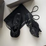 Sneaker nere di design con borsa minimalista, stile urbano, eleganza e funzionalità versatile.