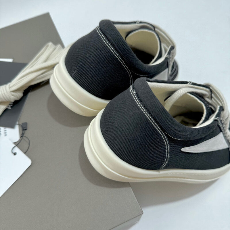 Scarpe sportive nere minimaliste con lacci, eleganti e versatili per look casual e urbano.