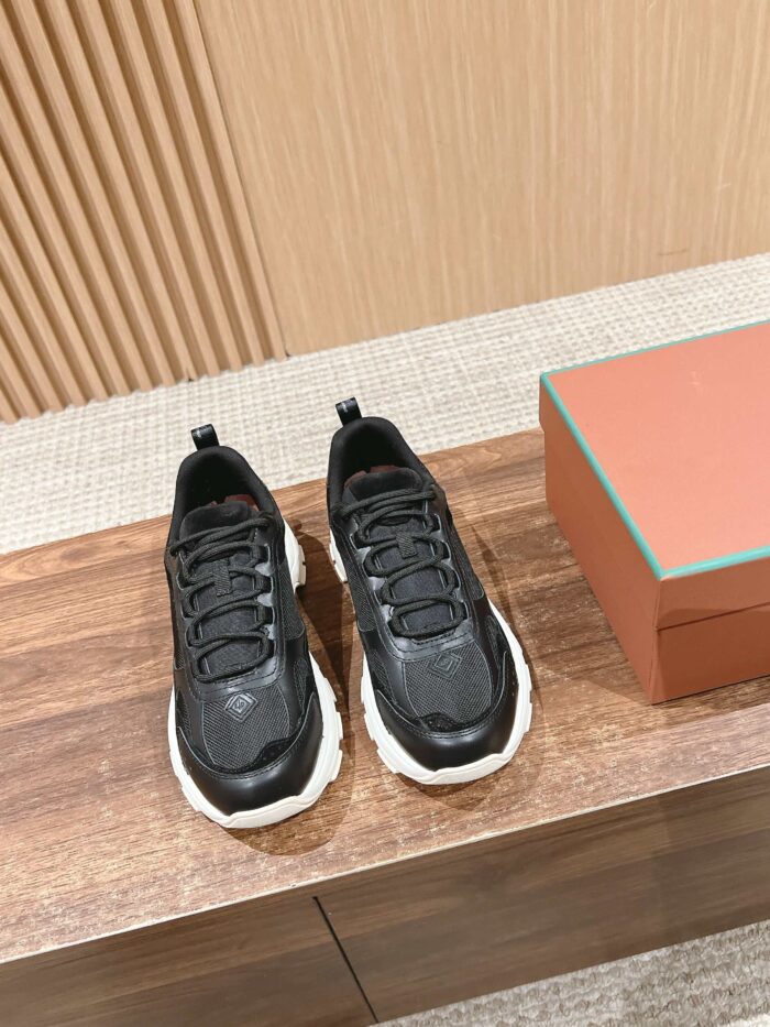 Scarpe da corsa nere con suola bianca su superficie in legno, ambiente elegante e moderno.