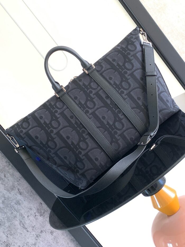 Borsa nera in tessuto e pelle elegante, con manici rinforzati e design minimalista sofisticato.