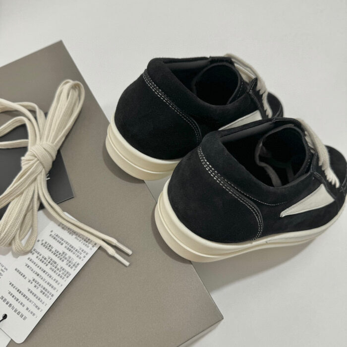 Sneakers nere in suede con lacci cream e suola bianca, stile moderno e versatile.