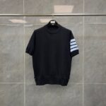 Maglietta nera con strisce blu, girocollo, dettaglio a bottoni, stile sporty e versatile.