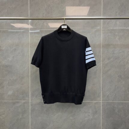 Maglietta nera con strisce blu, girocollo, dettaglio a bottoni, stile sporty e versatile.