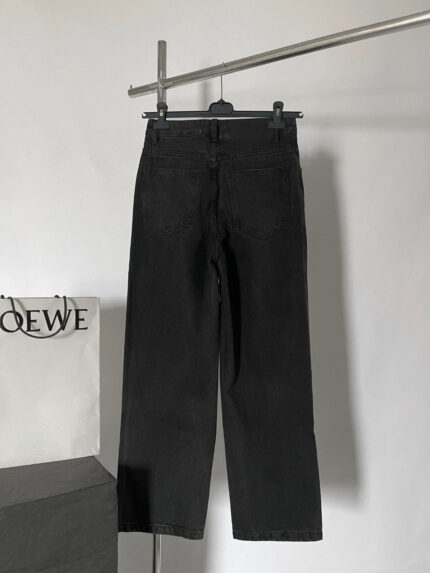 Pantaloni neri in denim con stile moderno e shopping bag Loewe di lusso.