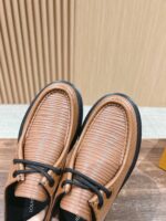 Scarpe in pelle caramello con lacci neri, stile elegante, versatile, ideali per ogni occasione.