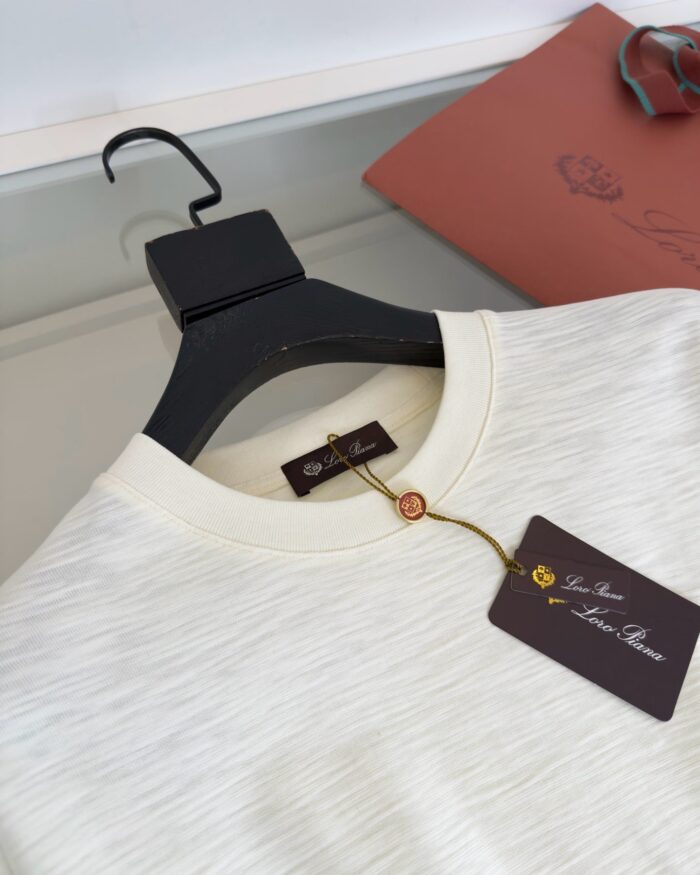 Maglietta crema di alta qualità con etichetta elegante in boutique raffinata.