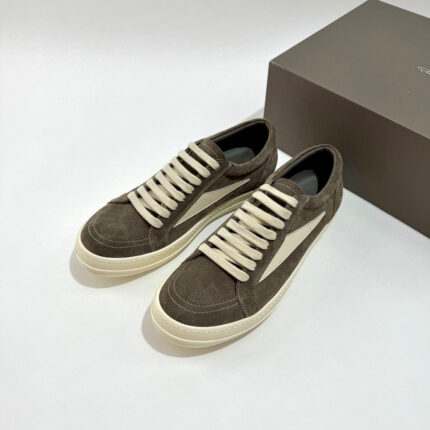 Scarpe sneakers in camoscio marrone scuro con lacci crema, stile elegante e casual.