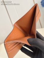 Portafoglio in pelle tan aperto con scomparti per carte, elegante e funzionale.