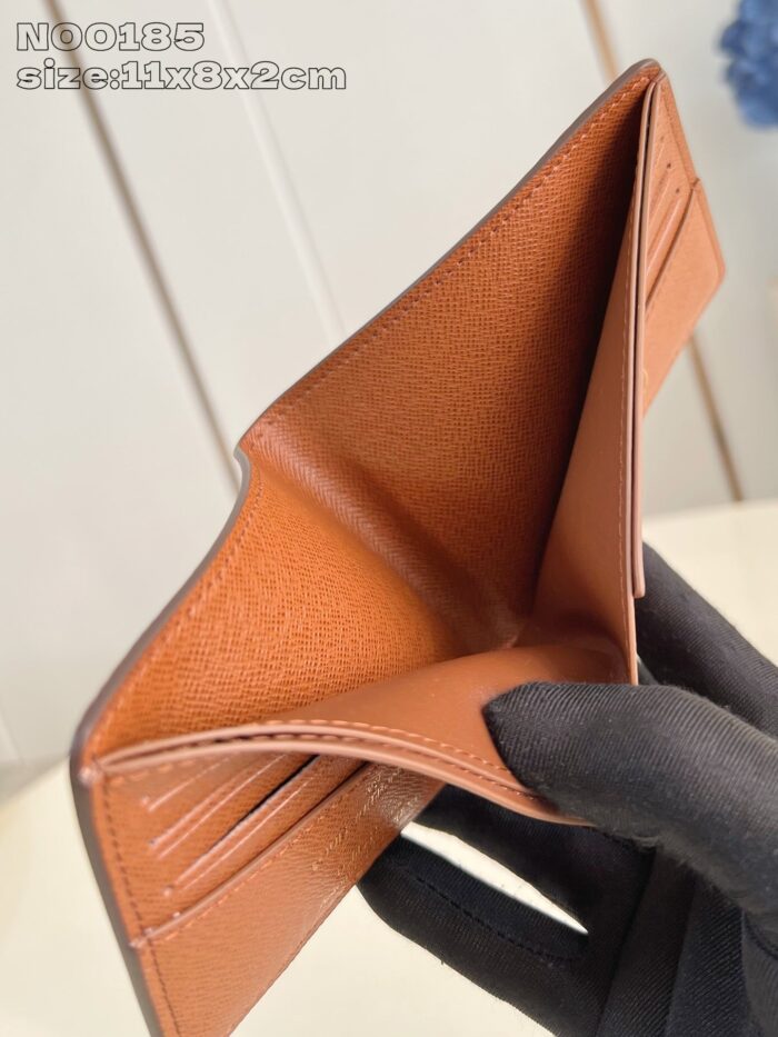 Portafoglio in pelle tan aperto con scomparti per carte, elegante e funzionale.