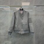 Giacca bomber grigia con zip, polsini a costine e dettagli sportivi sulle maniche.