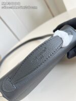 Borsa elegante in pelle grigia con manico ergonomico, dettagli di alta qualità e stile raffinato.