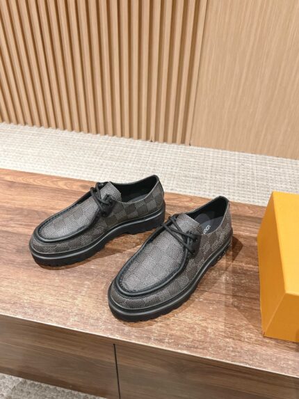 Scarpe da uomo grigie eleganti con suola robusta e scatola arancione, stile moderno e sofisticato.
