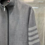 Giacca sportiva grigia con zip e dettagli a strisce sulle maniche, stile moderno e versatile.
