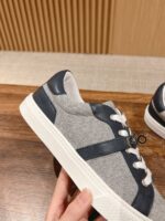 Scarpa sneaker grigia moderna con dettagli navy e suola bianca, comfort e stile casual.