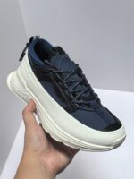 Scarpa sneakers moderna in navy con suola bianca spessa e dettagli neri, stile streetwear.