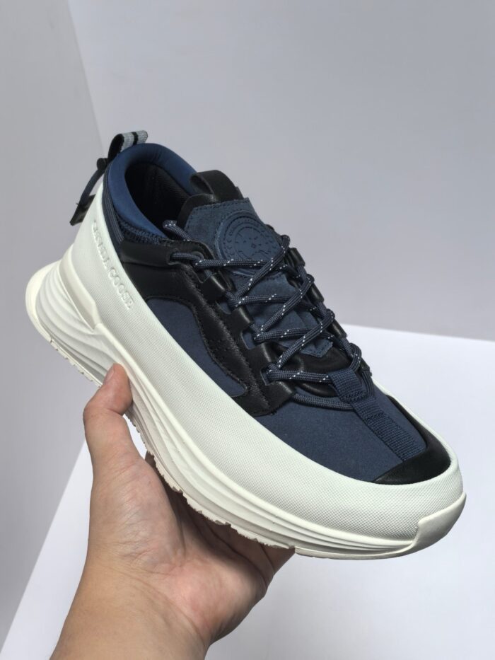 Scarpa sneakers moderna in navy con suola bianca spessa e dettagli neri, stile streetwear.