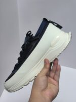 Sneaker moderna navy con suola bianca, traspirante e versatile per sport e stile casual.