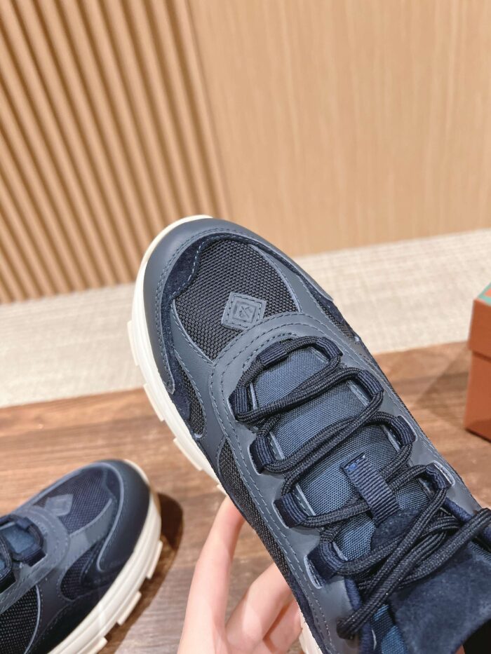 Sneaker blu scuro con suola crema, stile moderno e design versatile per sport e casual.