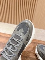 Sneaker sportiva grigia con lacci veloci, design moderno e materiali traspiranti.