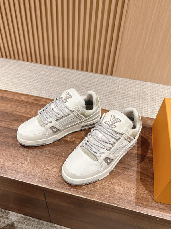 Sneakers bianche di lusso con packaging arancione, stile moderno e dettagli eleganti.