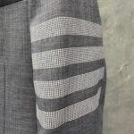 Manica in tessuto grigio con strisce moderne e motivo a quadri, stile elegante e contemporaneo.