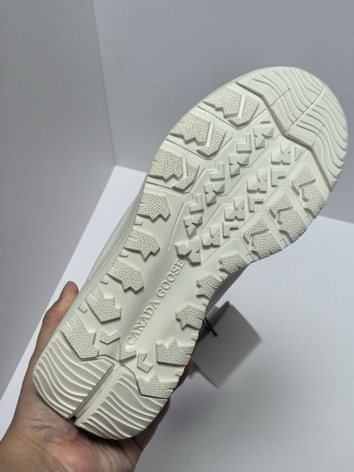 Suola sneaker bianca antiscivolo con design moderno e trame geometriche per stabilità.