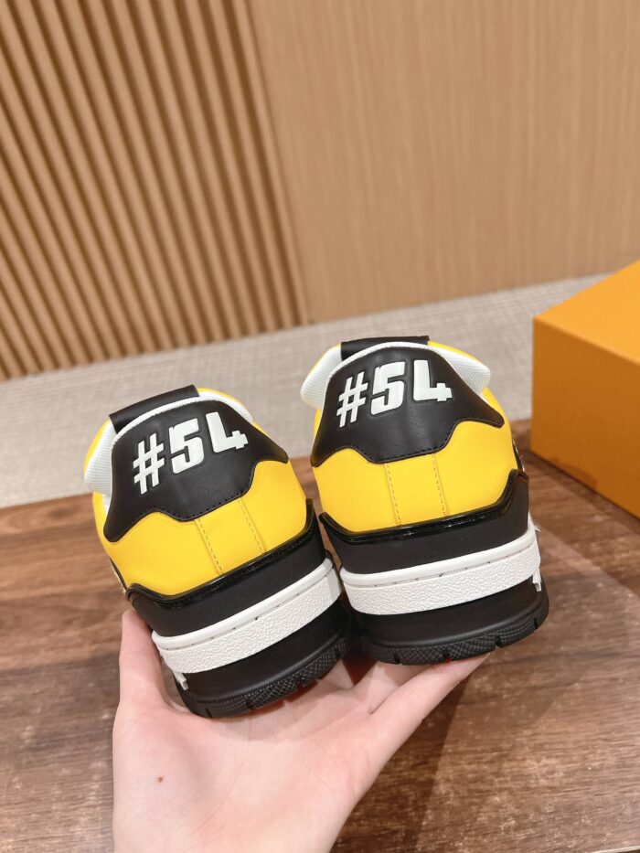 Sneakers gialli e neri con grafica #5L, design moderno e silhouette robusta.