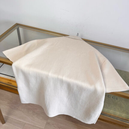 Tessuto beige su tavolo in vetro e legno, decorazione elegante e minimalista.