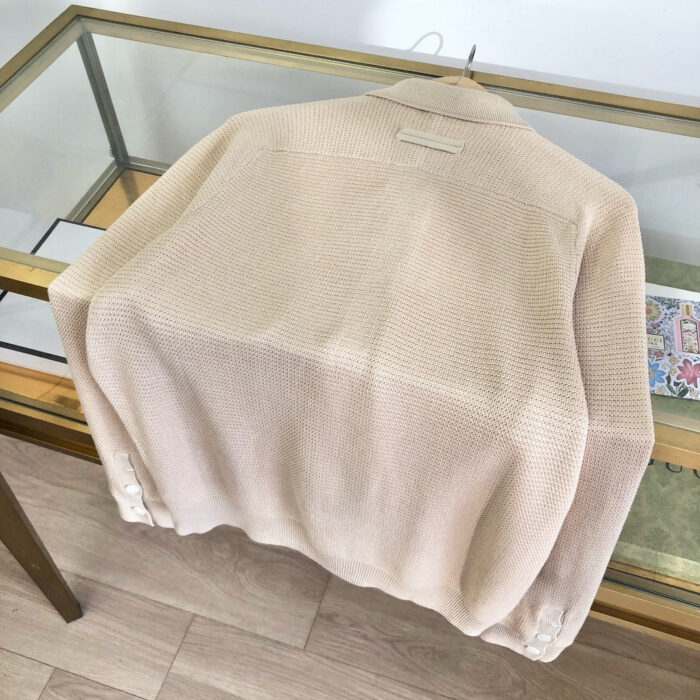 Maglione beige morbido e casual su tavolo di vetro, ideale per look comfy e autunnali.