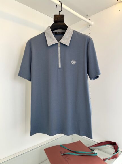 Polo blu soft con colletto bianco, zip frontale e logo discreto, perfetta per look casual.