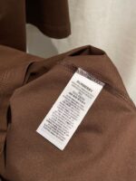 Etichetta su abbigliamento casual in tessuto morbido color castagna, stile confortevole e di qualità.