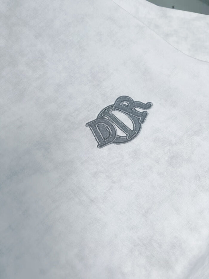 Maglietta casual bianca con logo monogramma grigio elegante e dettagli sottili.