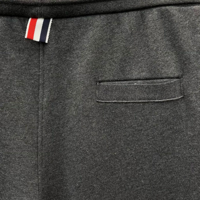 Pantaloni jogger grigi casual con elastico, tasca e dettagli tricolore, comodi e trendy.