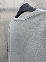 Maglietta grigia casual con dettagli grafici, tessuto morbido e stile confortevole.