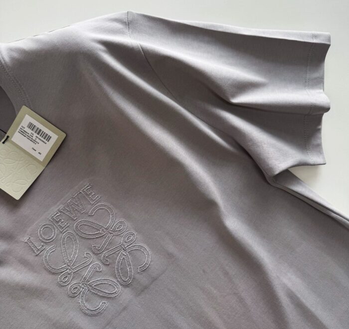 T-shirt grigia morbida con ricamo tono su tono, stile casual e raffinato.