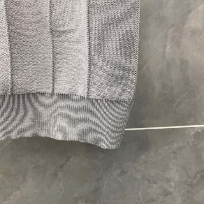 Maglione grigio a coste in tessuto morbido, elegante e versatile per look casual o raffinato.