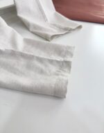 Maniche in lino leggero con polsini cuciti, contrasto elegante con dettaglio in pelle morbida.