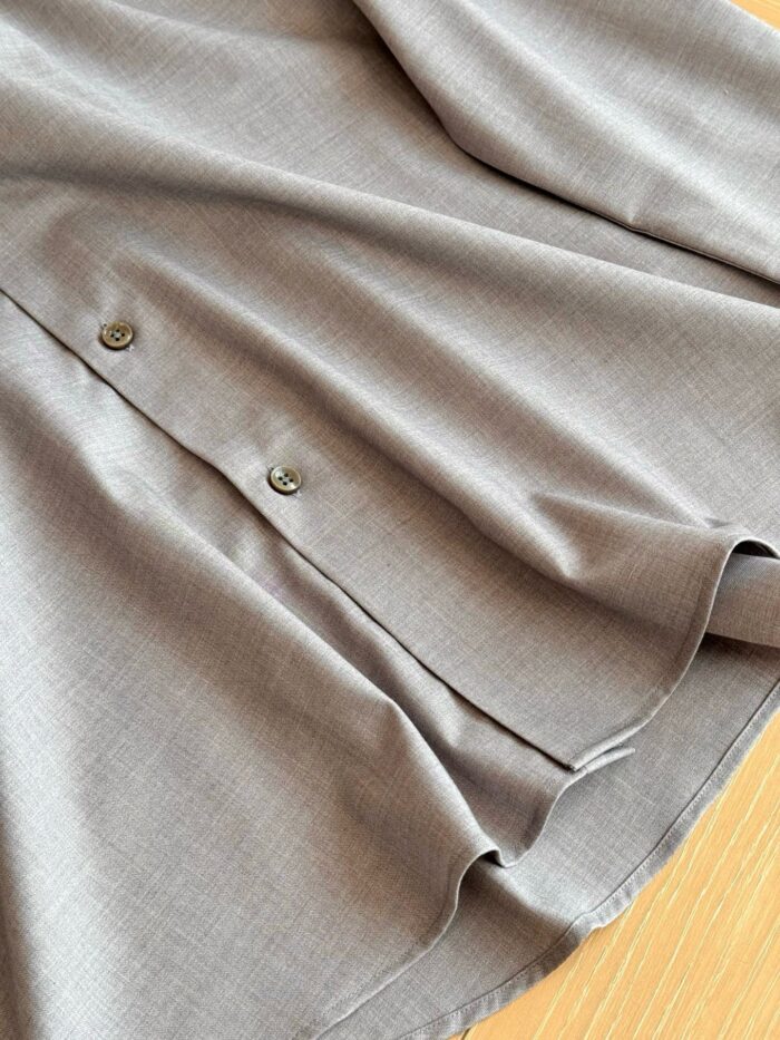 Blusa grigia elegante con bottoni metallici e tessuto morbido, perfetta per occasioni raffinate e casual.