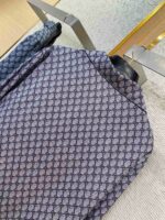 Giacca moderna con motivo geometrico in tessuto satinato blu e grigio, stile elegante.