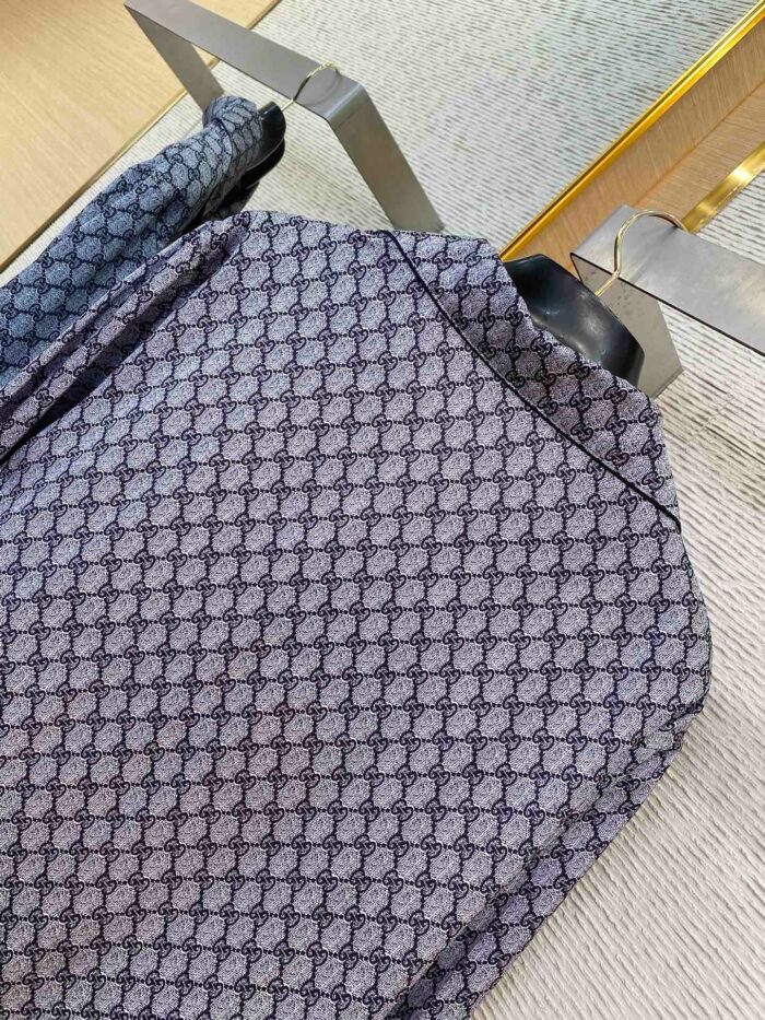 Giacca moderna con motivo geometrico in tessuto satinato blu e grigio, stile elegante.